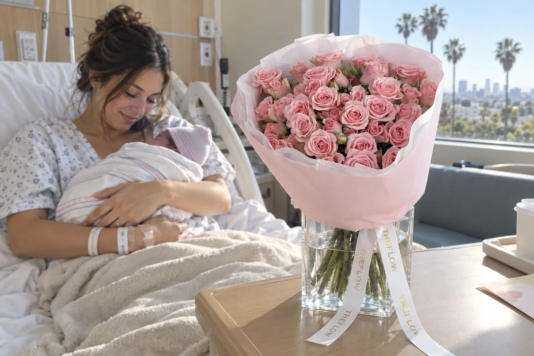 Pink roses in a vase by a hospital bed